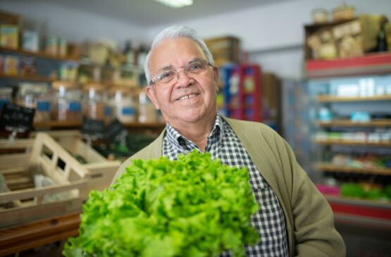 Man in Plaid Shirt Holding a Green Vegetable